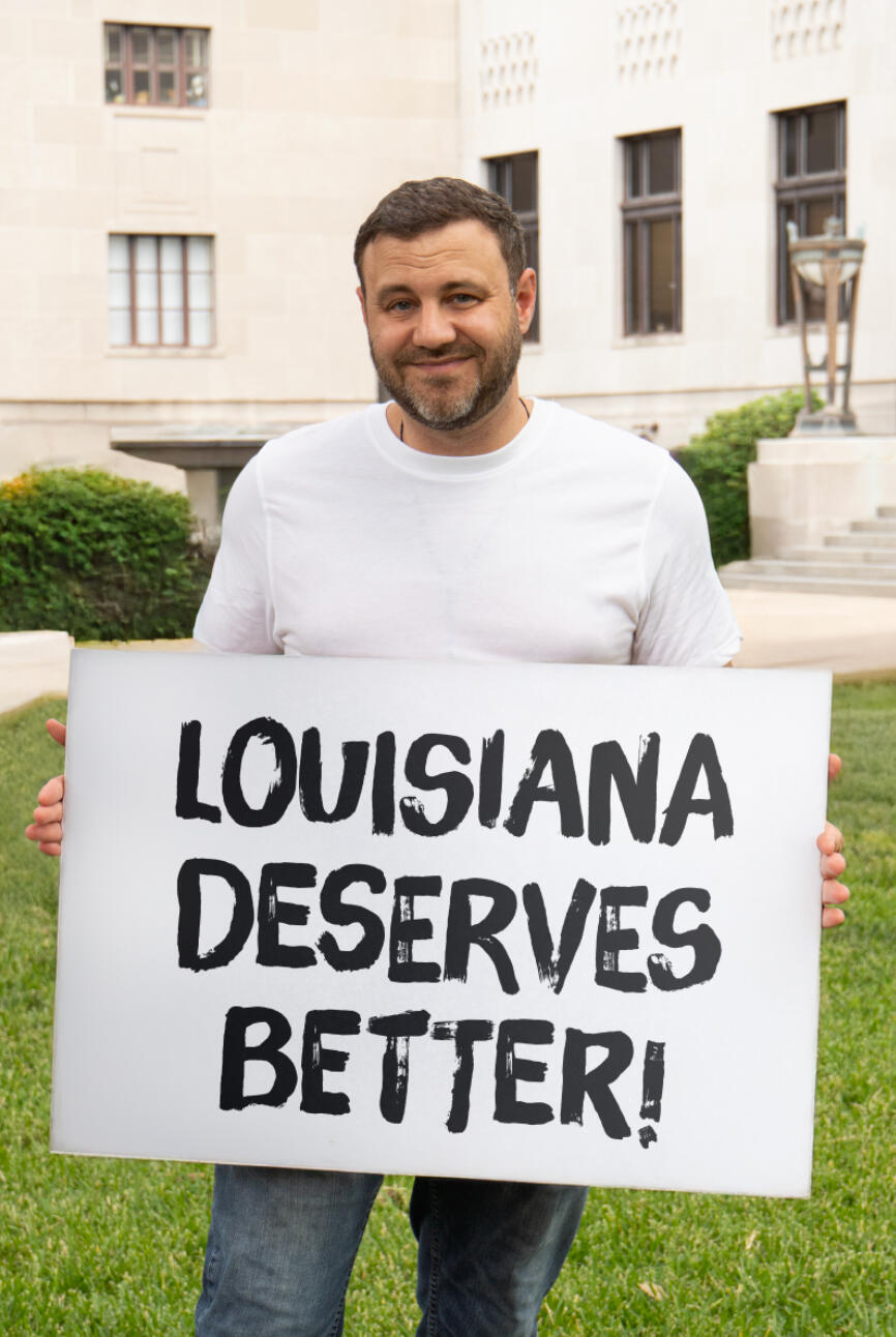 Matt Gromlich Protest Matt Gromlich holding a sign saying "Louisiana Derserves Better"